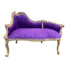 a purple couch sitting on top of a white floor next to a wooden frame with gold trim