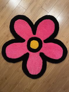 a pink and black rug with a flower on it's center is laying on the floor