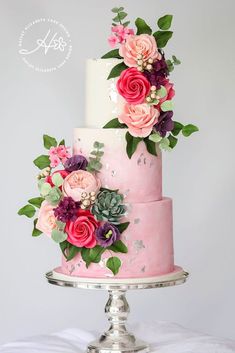 a three tiered cake with pink and purple flowers