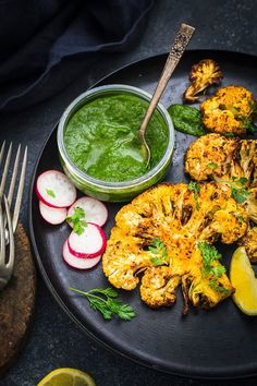 grilled shrimp with pesto sauce and radishes on a black plate