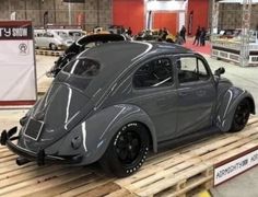 a gray car sitting on top of a wooden pallet