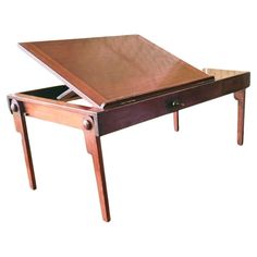 a wooden table with drawers on the bottom and one drawer open to reveal an object