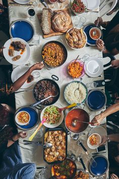 an overhead view of people eating at a table with plates and bowls of food on it