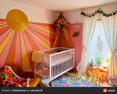 a baby's room decorated in pink, yellow and orange with sunburst