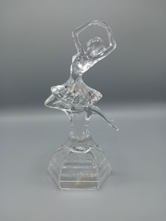 a glass figurine sitting on top of a clear base with a ballerina figure in the middle