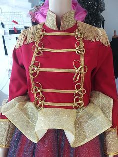 a mannequin dressed in a red and gold dress with golden trimmings