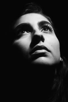 a black and white photo of a woman's face with her eyes wide open