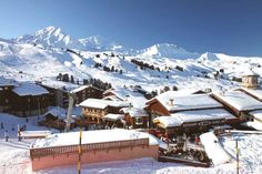 a ski resort with snow covered mountains in the background