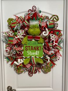 a christmas wreath with the grinch saying stay stank stink on it's front door