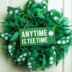 a green wreath with white polka dots and an anytime is tee time sign on it