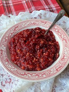 a white bowl filled with cranberry sauce on top of a lace doily