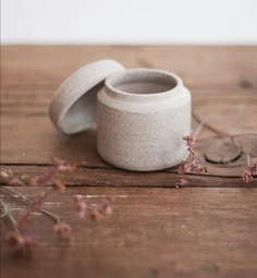 two white vases sitting on top of a wooden table