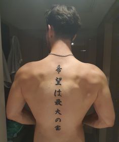 the back of a man's body with chinese writing on his upper and lower back