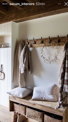 a coat rack with towels hanging on it and two baskets under the hooks holding coats