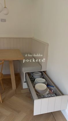 an open drawer in the middle of a kitchen next to a dining room table and chairs