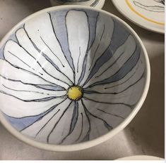 three bowls with designs painted on them sitting next to each other and one has a yellow center in the middle