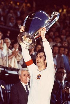 a man holding up a trophy in front of a crowd