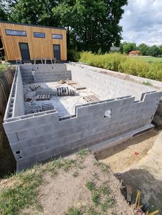 a building being built in the middle of a field with grass and dirt around it