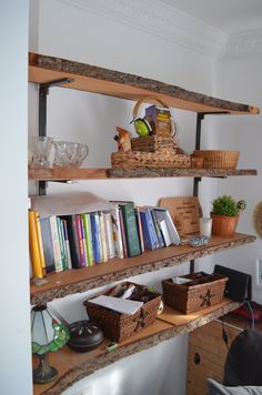 two wooden shelves with books and baskets on them