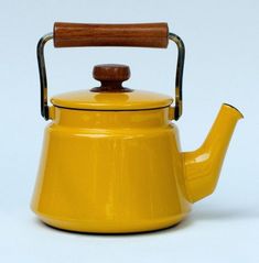 a yellow tea kettle with a wooden handle