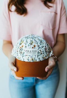 a woman holding a hat with the word praise printed on it