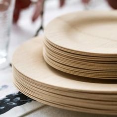 stack of wooden plates sitting on top of a table