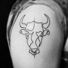 a bull's head tattoo on the upper arm