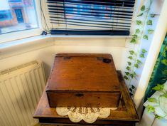 an old wooden box sitting on top of a table next to a radiator