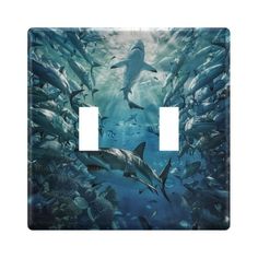 a light switch cover with dolphins swimming in the ocean and sharks on it's side