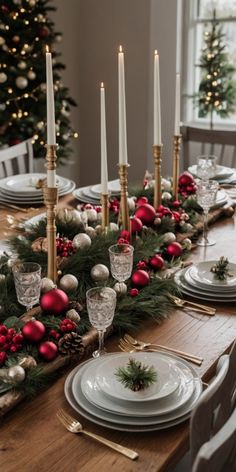 a dining room table decorated for christmas with candles, ornaments and plates on the table