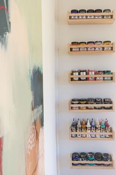 the shelves are filled with different types of paint