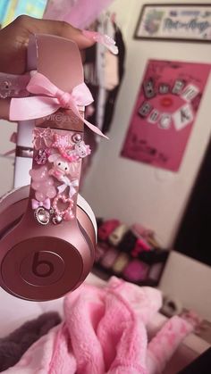 a person is holding up headphones with pink bows and teddy bears on them,