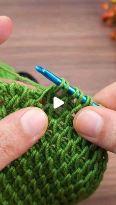 someone is crocheting the stitchs on their green bag