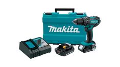 a cordless drill with two batteries and a tool box next to it on a white background