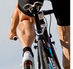 a close up of a person riding a bike on the road with their feet in the air