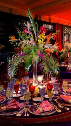 the table is set with flowers, candles and place settings for an elegant dinner party