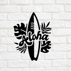 a surfboard with the word aloha on it is shown against a white brick wall