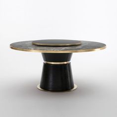 a black and gold table with two plates on it's top, sitting in front of a white background