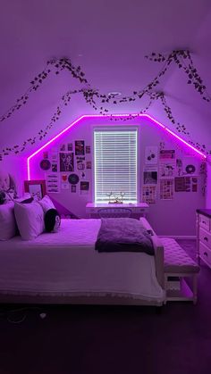 a bedroom with purple lighting and pictures on the wall above the bed is lit up