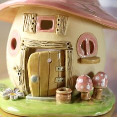 a ceramic house with mushrooms around it