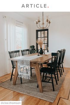 a dining room table with black chairs and a chandelier