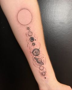 a woman's arm with planets on it