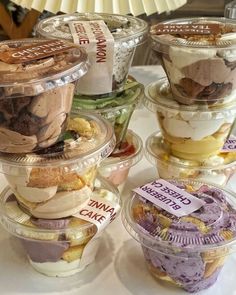 an assortment of desserts in plastic containers on a table