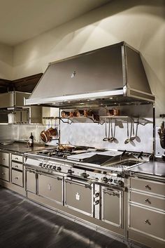 a large kitchen with stainless steel appliances and counter tops is pictured in this image from the front view