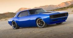 a blue muscle car parked in the desert