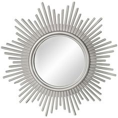 a silver sun mirror on a white wall