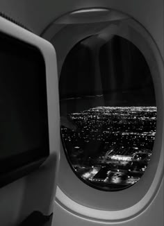 an airplane window looking out at the city lights