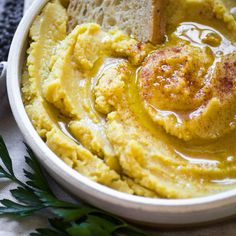 a white bowl filled with hummus and bread