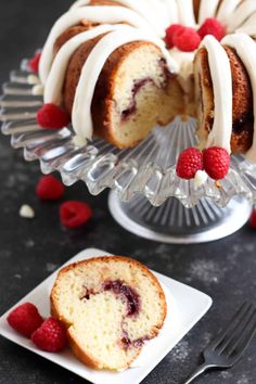 a bundt cake with white frosting and raspberries