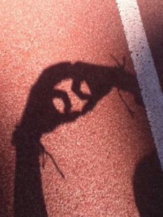 the shadow of a person's hand holding a tennis racquet